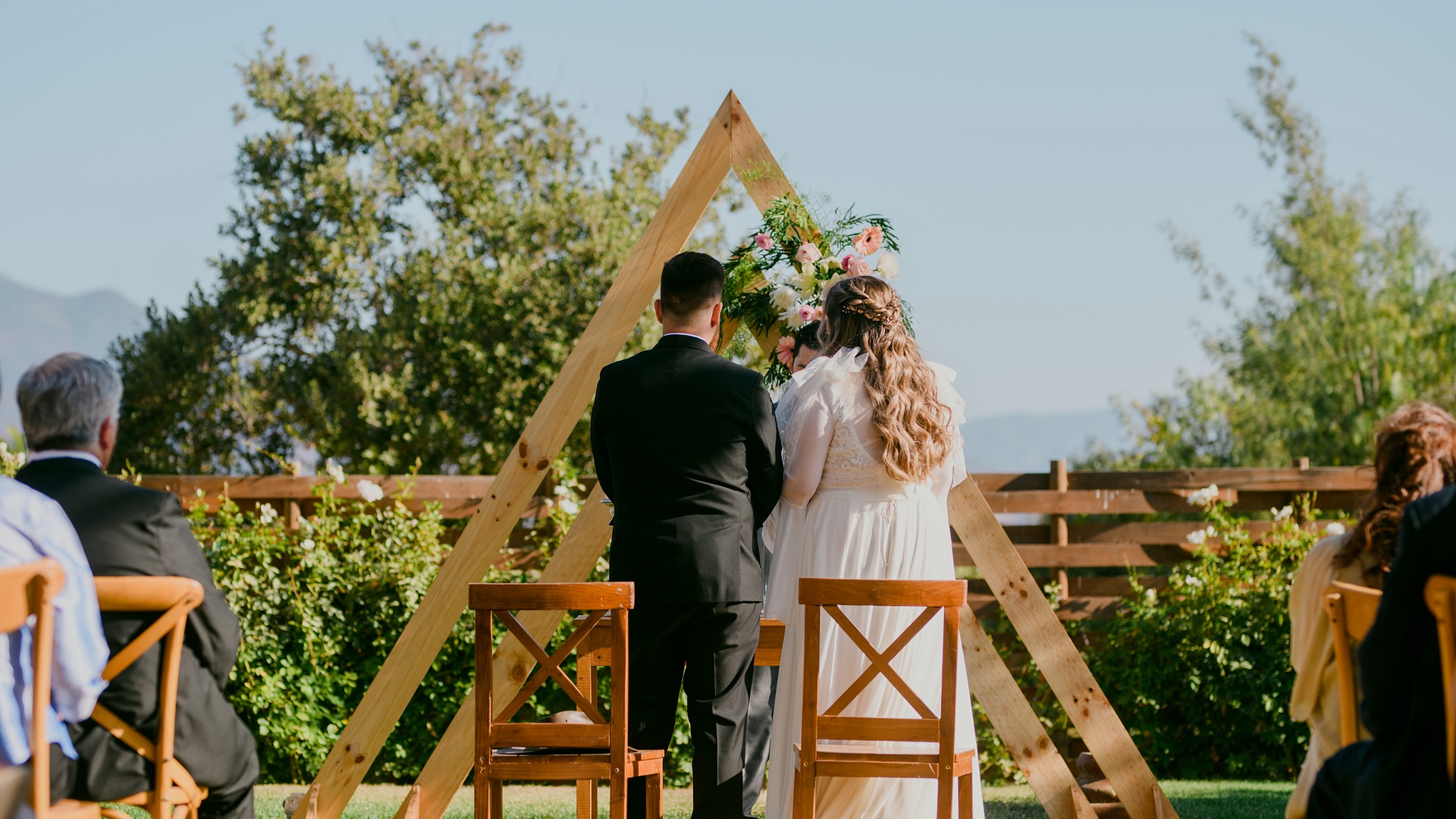 Ceremonia de matrimonio bajo un arco de madera con vista a la cordillera, en Olmué Natura
