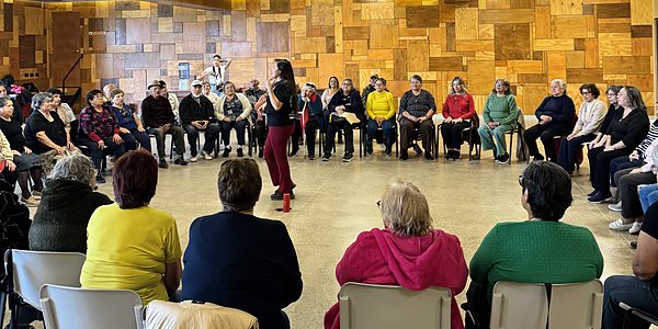 Grupo de adultos mayores en actividad guiada en el salón de Olmué Natura